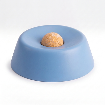 Blue slow feeder dog bowl with textured rolling ball on a white background