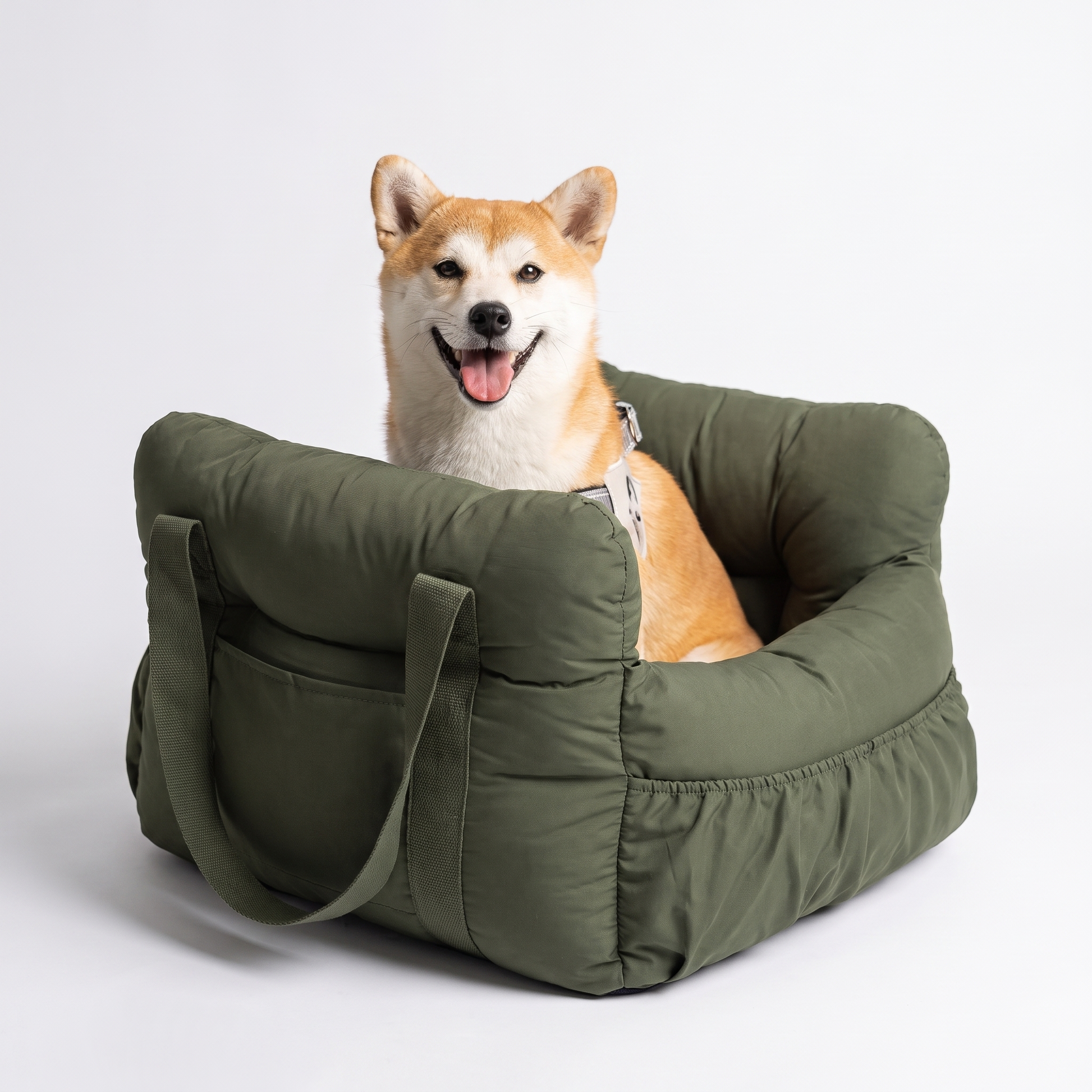 Happy dog sitting in the olive green portable booster car seat lookout bed
