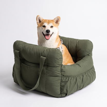 Happy dog sitting in the olive green portable booster car seat lookout bed