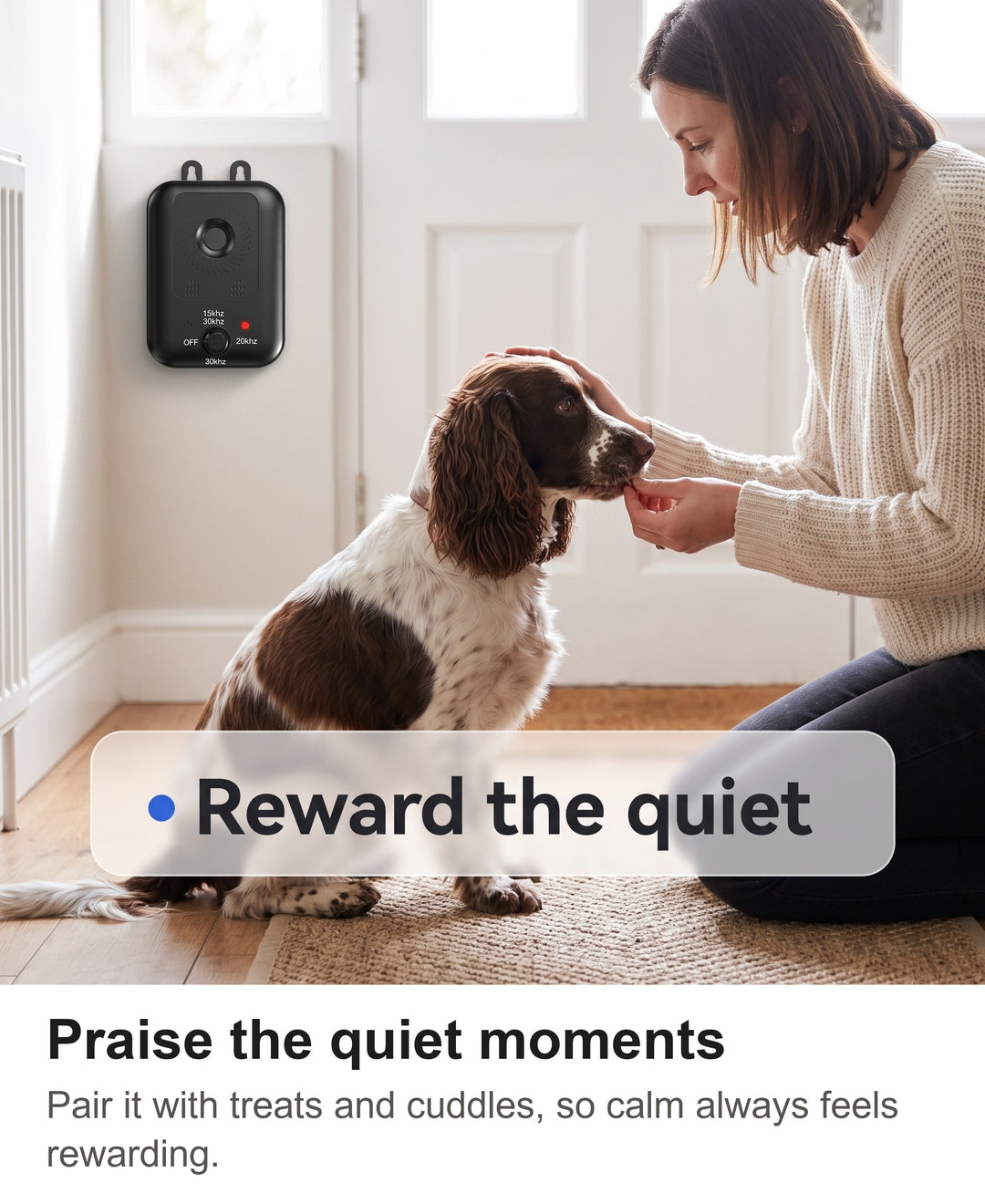 Woman giving a treat to a calm cocker spaniel in a hallway with the anti bark device on the wall