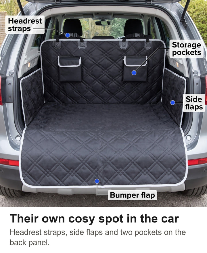 Black quilted boot liner fitted in an SUV with headrest straps, pockets, side flaps and bumper flap labelled