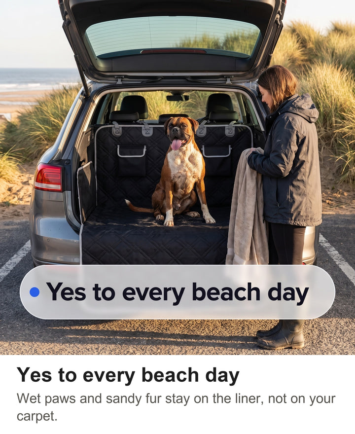 Boxer sitting in a car boot lined with the black quilted liner after a beach walk