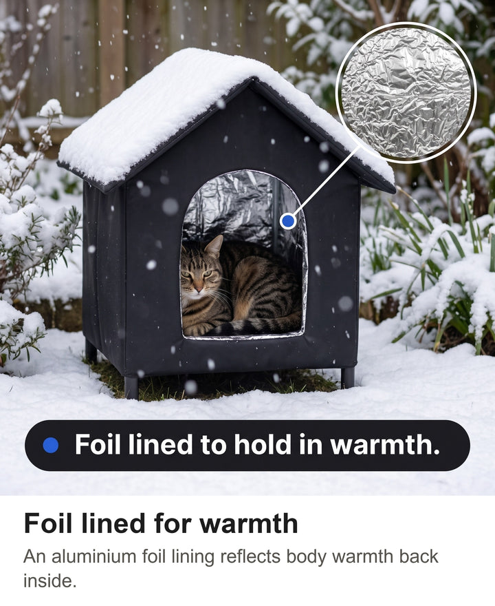 Cat curled up inside the foil lined outdoor cat house in the snow