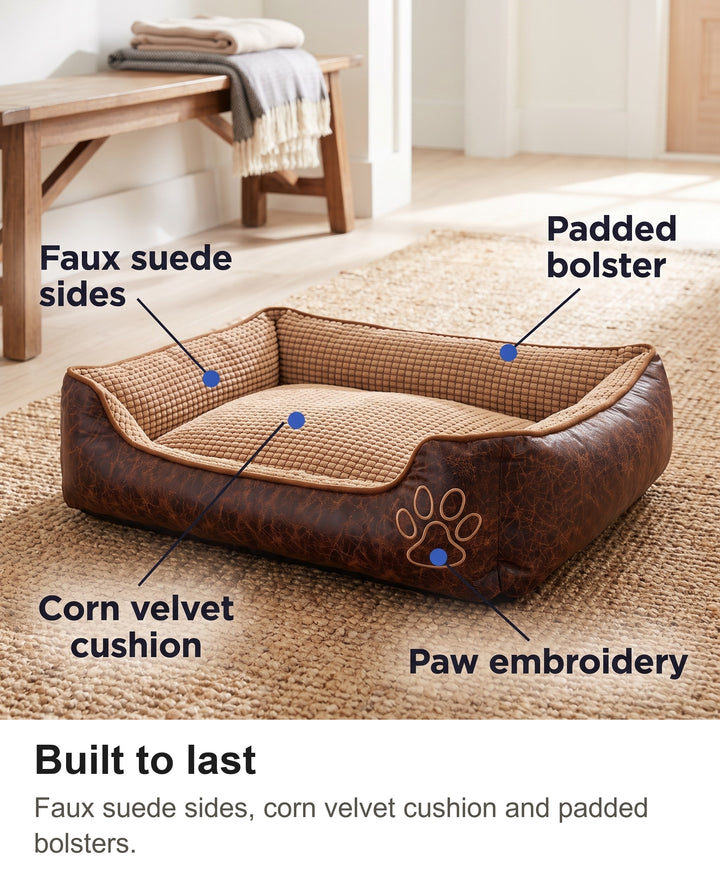 Bolster dog bed with faux suede sides, corn velvet cushion, paw embroidery and padded bolster labelled
