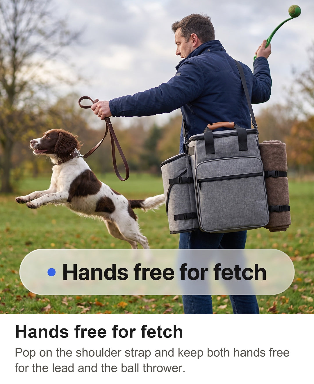 Man throwing a ball with a ball thrower on a field wearing the grey dog bag on his shoulder strap