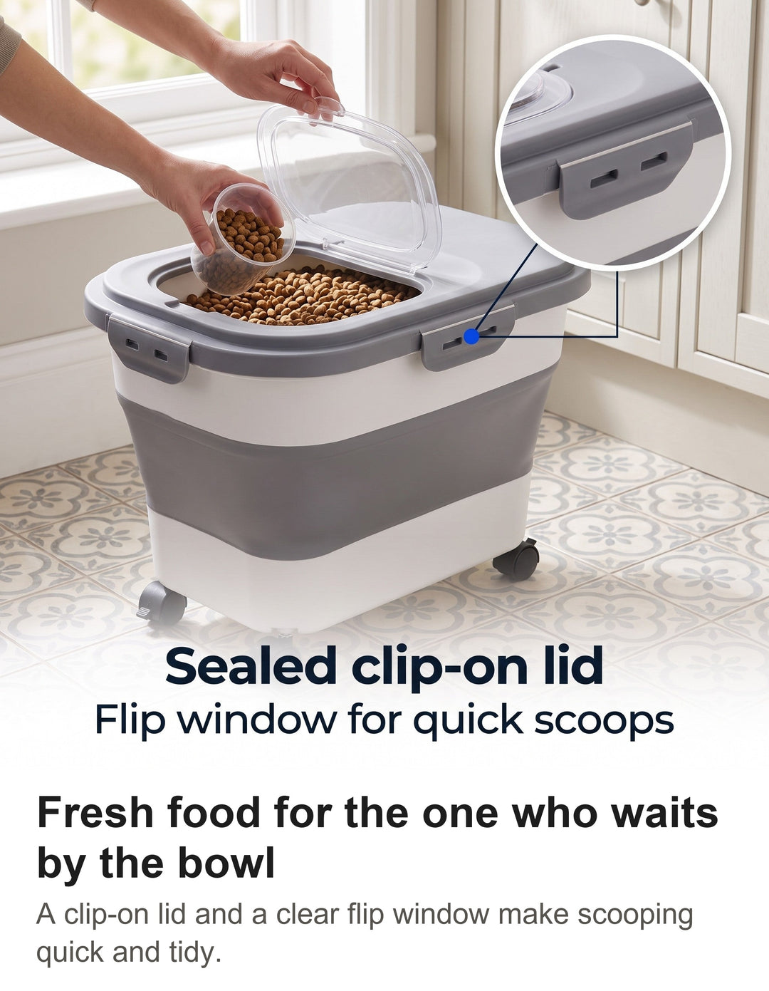 Hand scooping kibble through the flip window of a grey dog food storage container in a kitchen