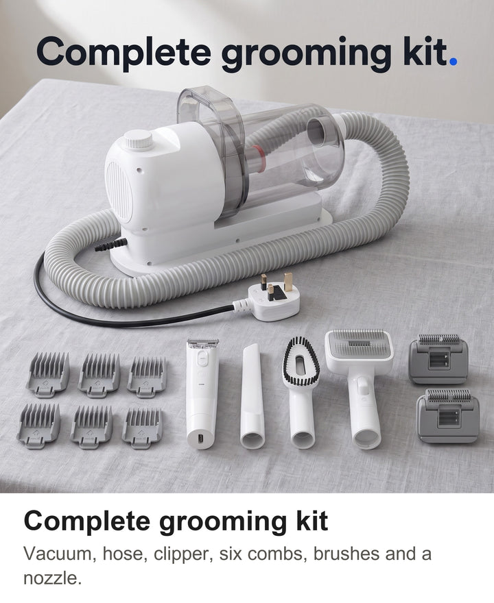 Everything in the dog grooming kit laid out: vacuum, hose, clipper, six combs, brushes and nozzle