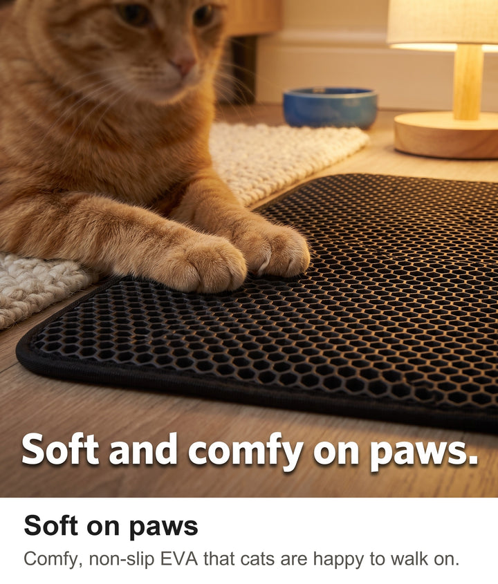 Ginger cat paws resting on the soft honeycomb of the cat litter mat
