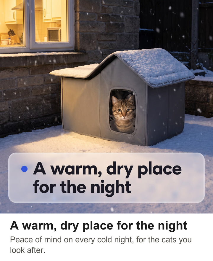Grey outdoor cat house in a snowy garden at night with a cat inside