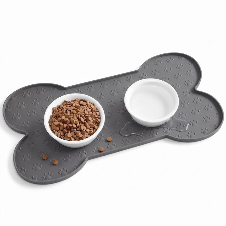 Grey silicone dog food mat with raised edge holding a bowl of kibble and a bowl of water