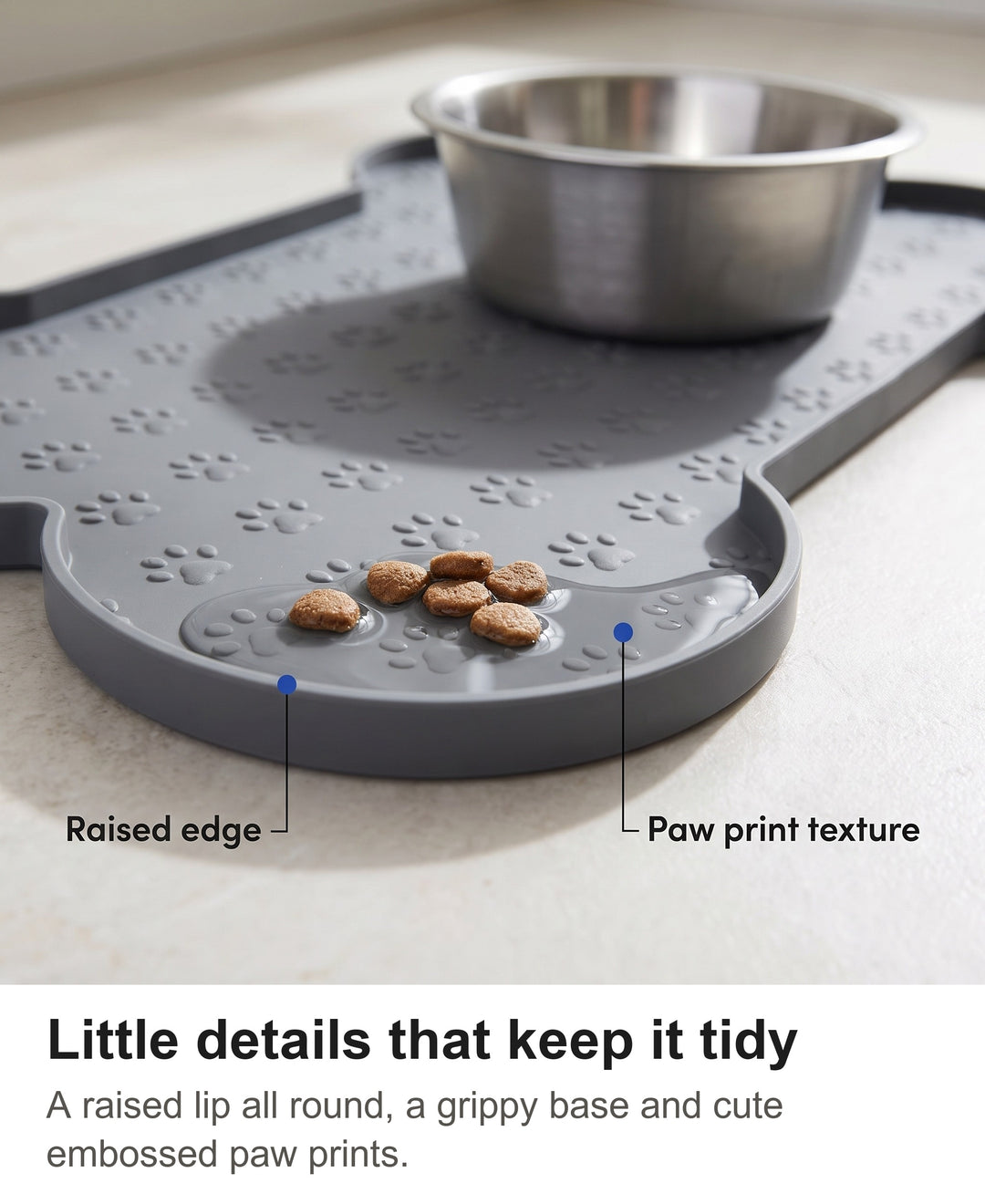 Close-up of the raised edge and embossed paw prints on the grey silicone dog food mat