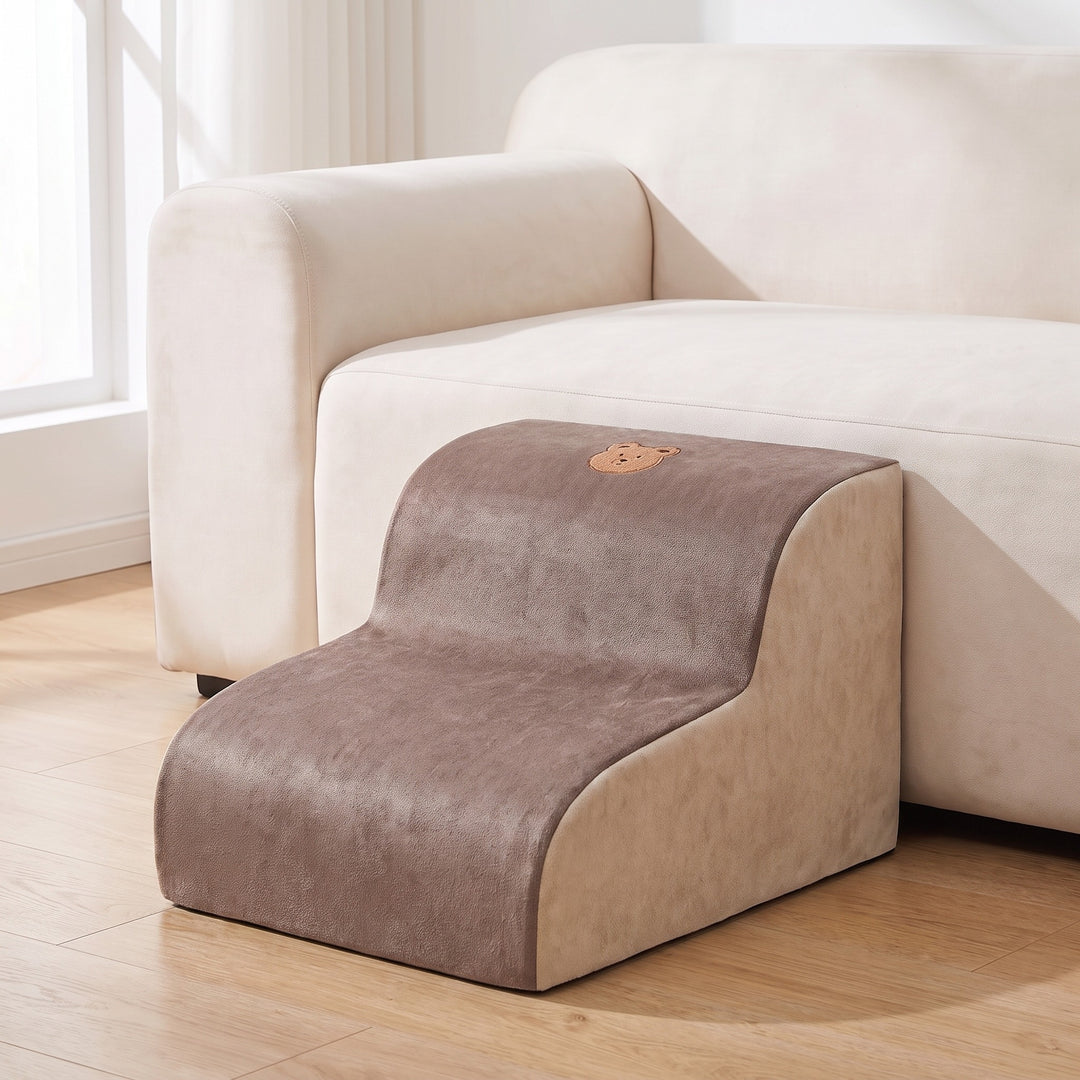 Brown and cream foam dog steps with 2 steps beside a light sofa in a bright living room