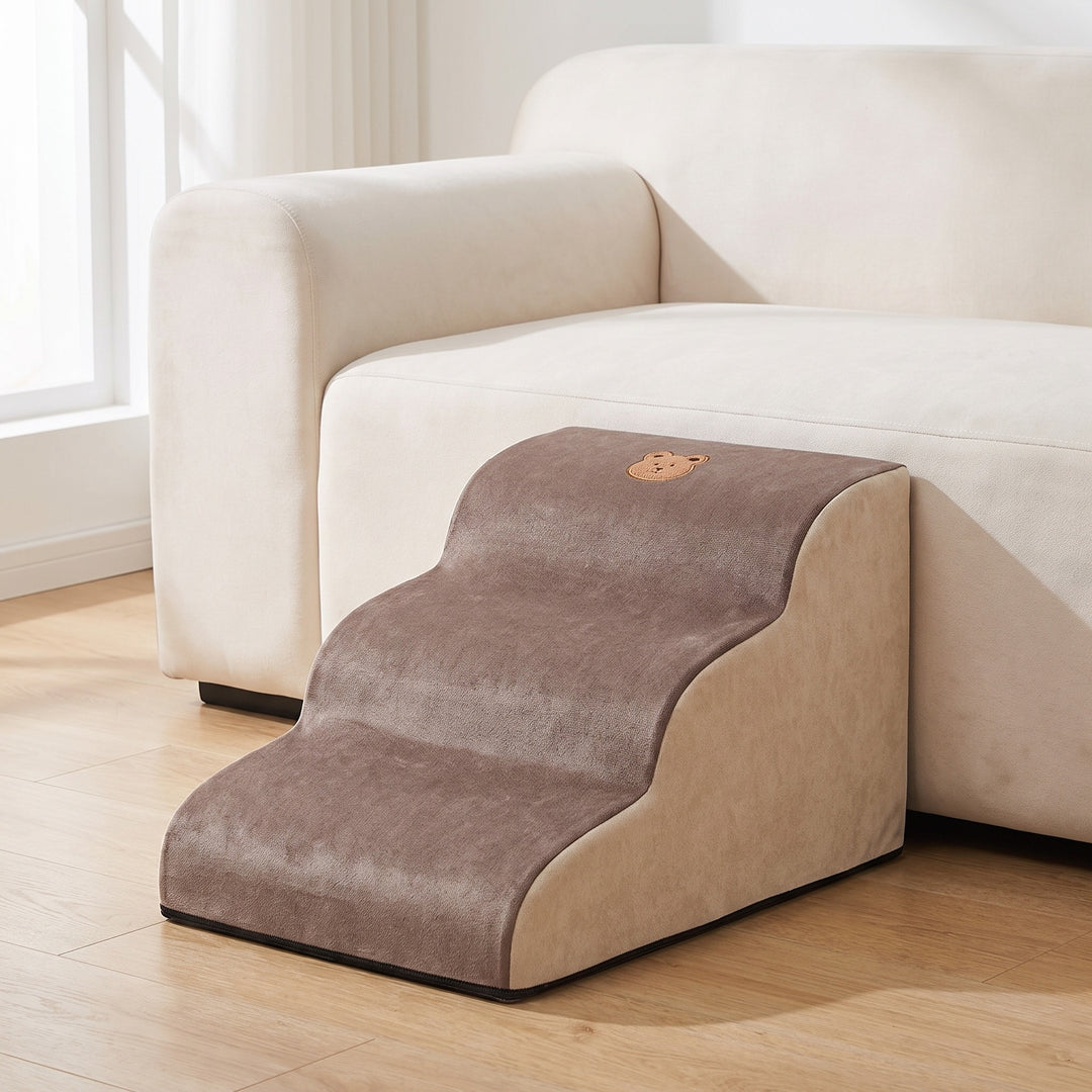 Brown and cream foam dog steps with 3 steps beside a light sofa in a bright living room