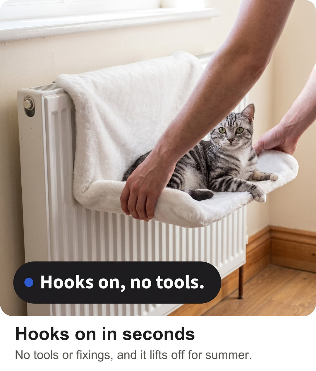 Hands hooking the metal frame of the cat hanging bed over the top of a radiator