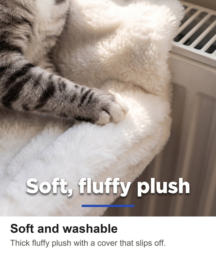 Close-up of a cat paw resting on the thick fluffy plush of the radiator hammock