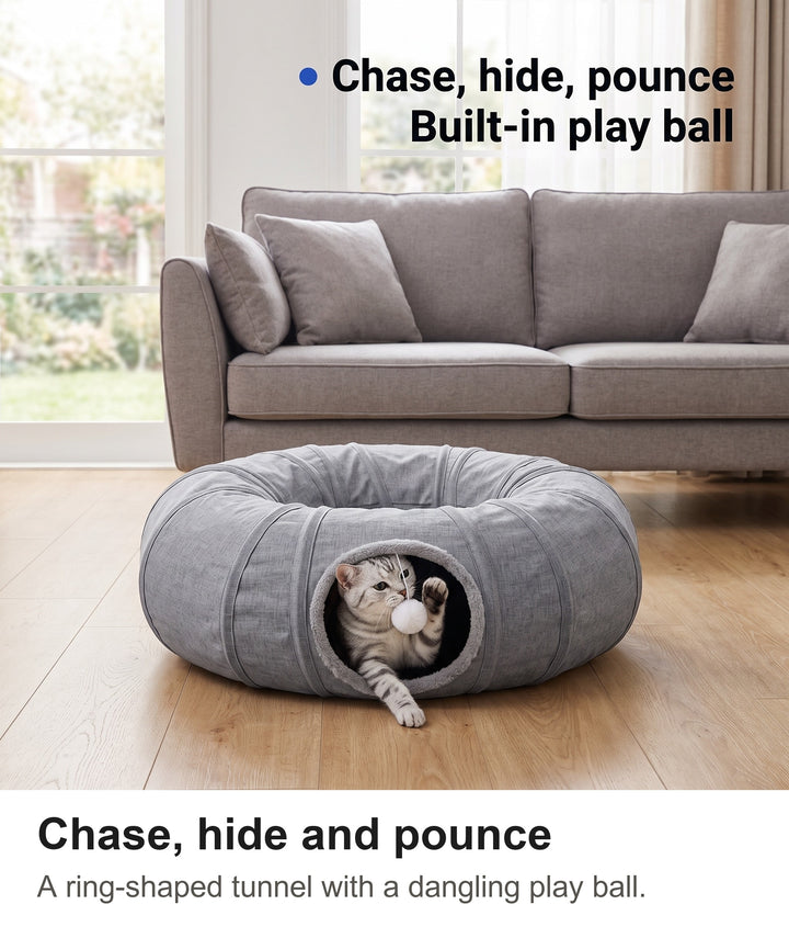 Silver tabby cat peeking out of the cat tunnel entrance and batting the dangling play ball