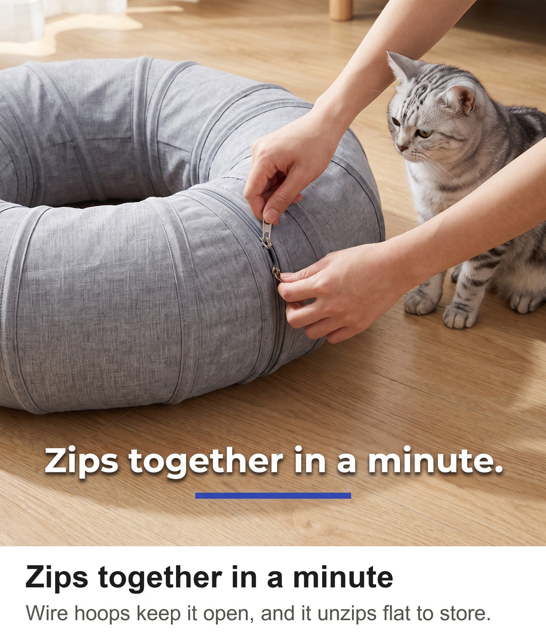 Hands zipping the two ends of the cat tunnel together into a ring