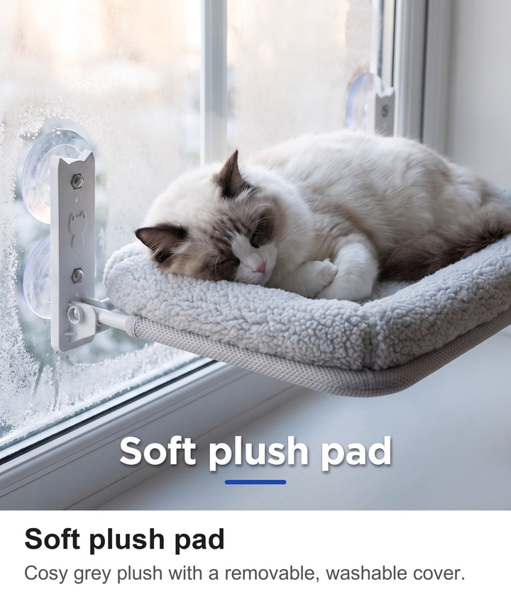 Ragdoll cat asleep on the soft grey plush pad of the window bed
